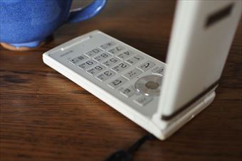 携帯 ケータイ 開いている 青いカップ